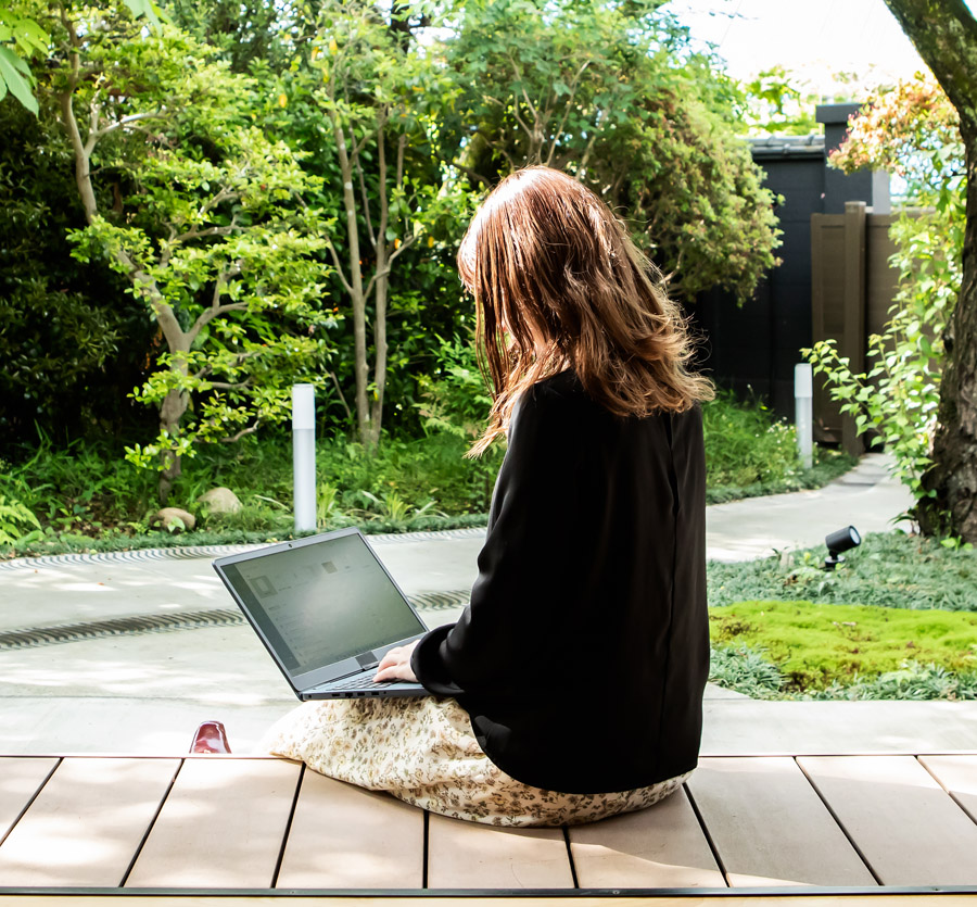 Woman sitting on deck on computer