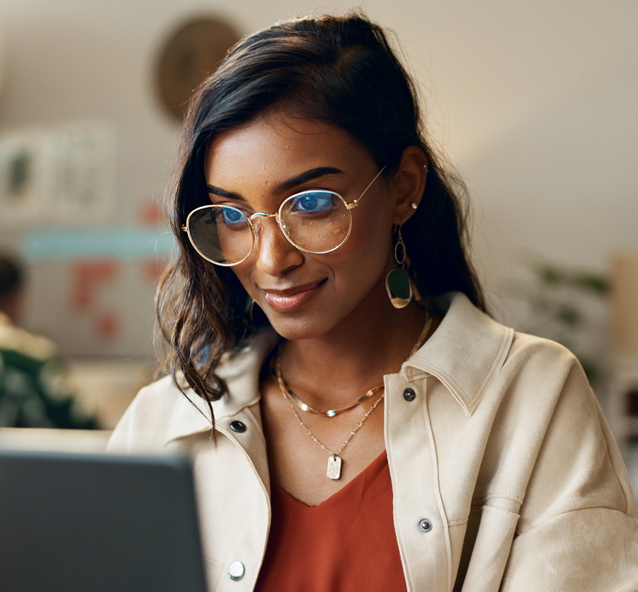 Young woman sits facing a computer.