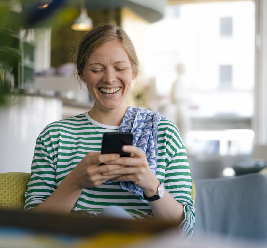 Woman holding mobile phone laughing