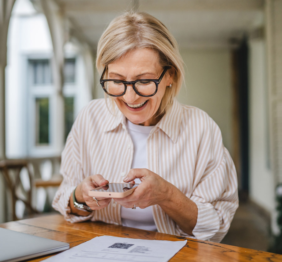 Mature woman scanning code on mobile phone