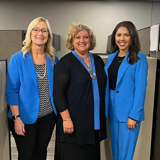 Three bank professionals smile for the camera. 