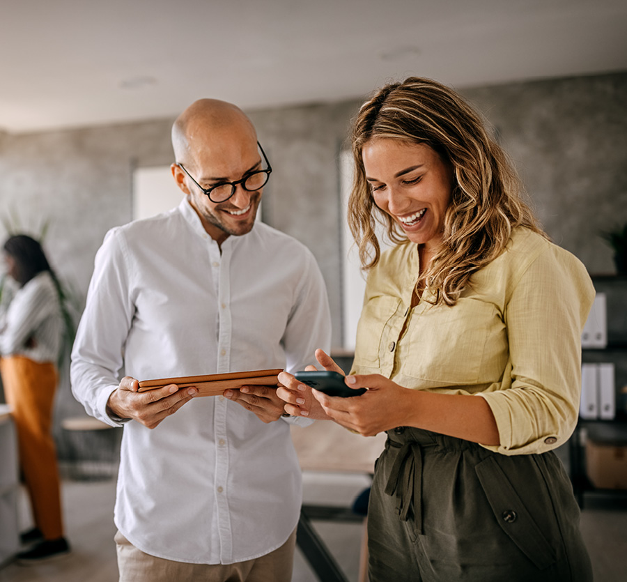 Coworkers check digital devices