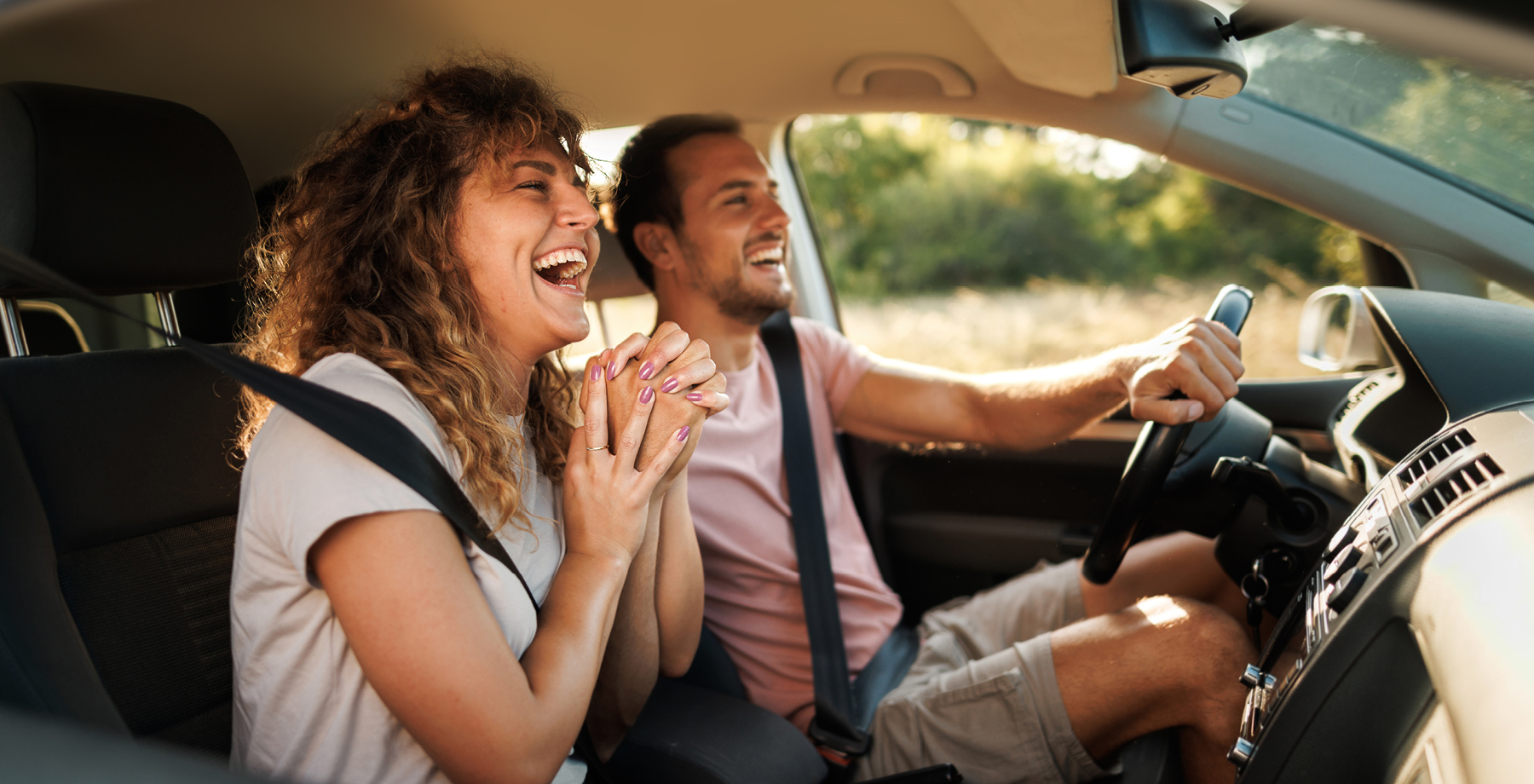 A happy couple driving in a car.