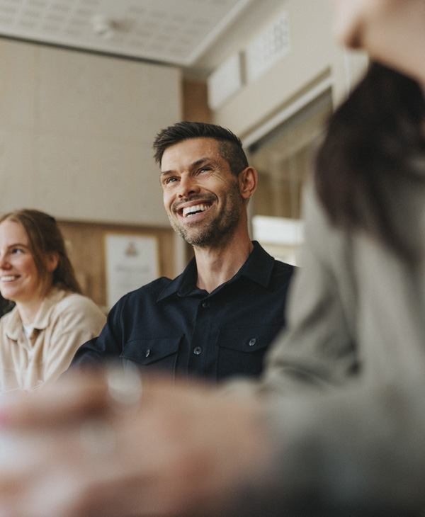 Happy man sitting with peers