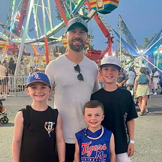 Father and three young sons enjoying the local county fair.
