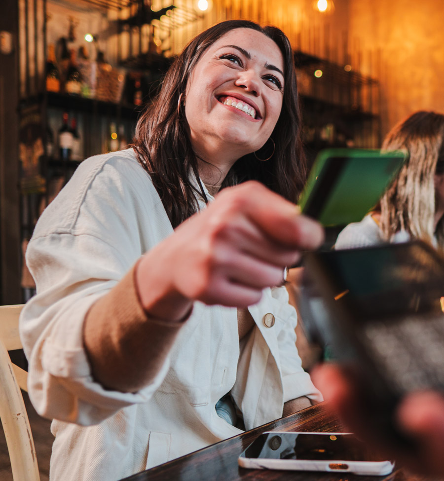 Young adult paying with card at restaurant
