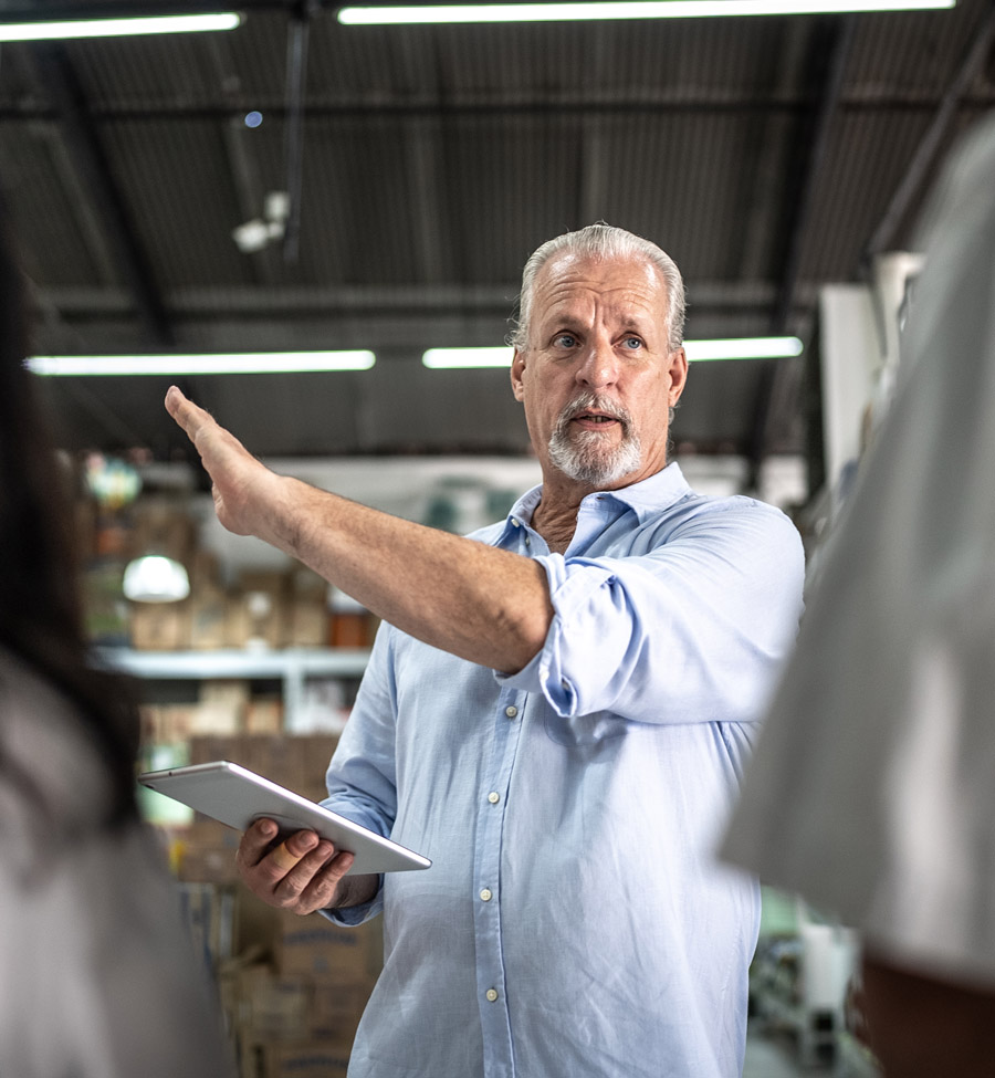 A gesturing man leads a meeting for his employees.