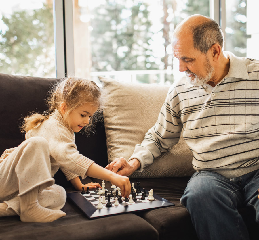 Grandfather and granddaughter playing chess