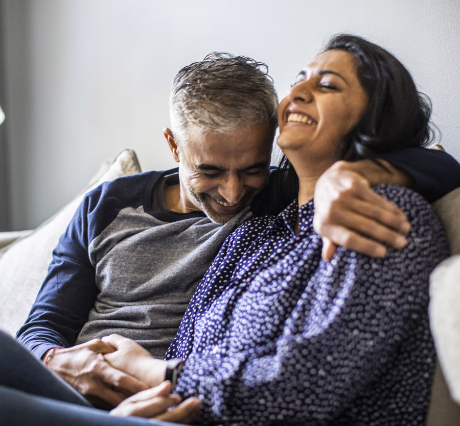 Middle age couple on couch laughing