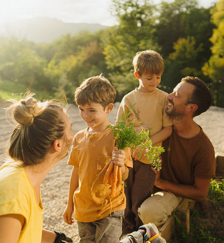 Young family outdoors with young son holding herbs